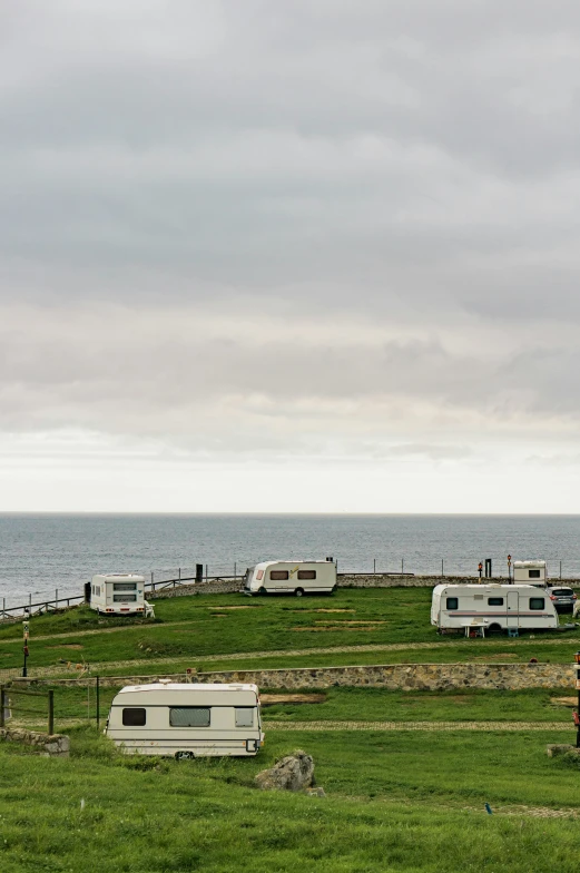 several recreational vehicles parked in an area near the ocean
