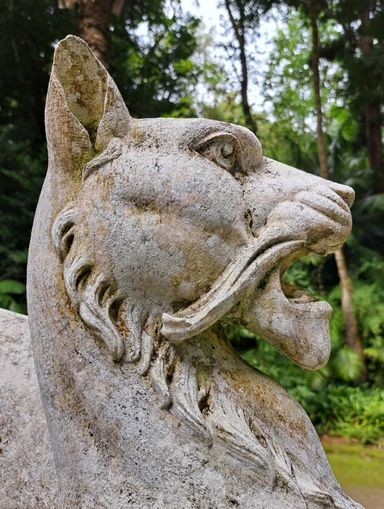 a stone statue of a dog with its mouth open