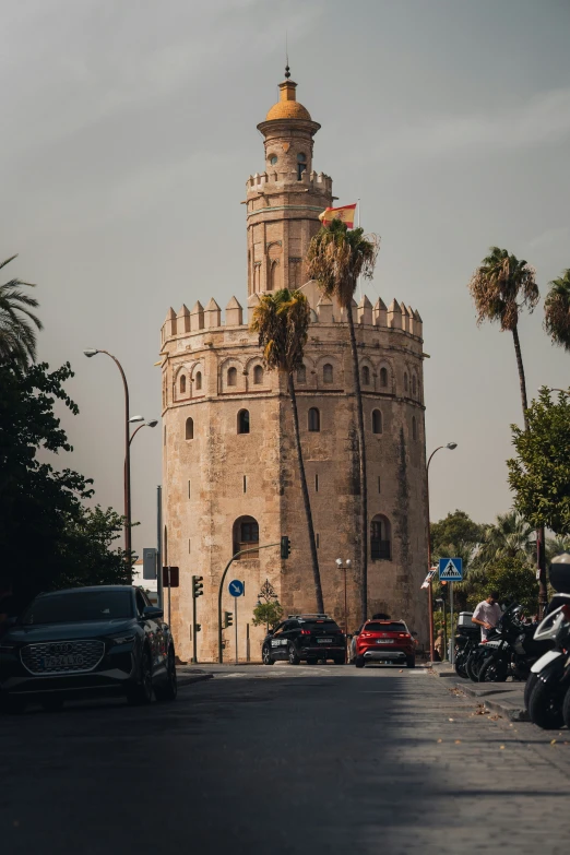 a tall tower with a clock and some cars