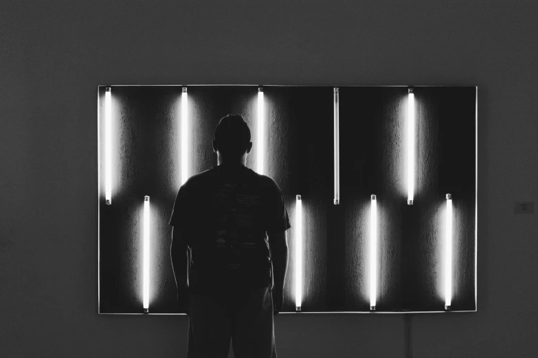 a man standing in front of a wall made of mirrors