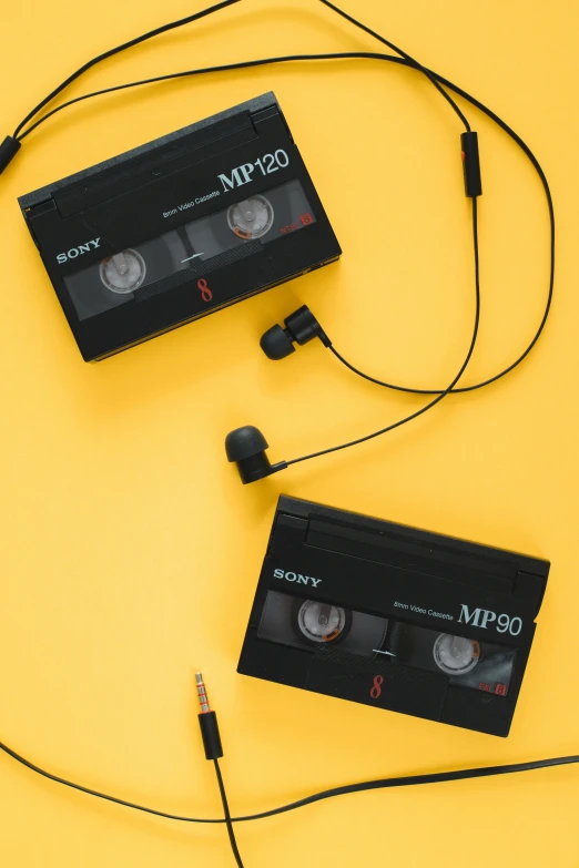 two old black cassette disks connected with headphones