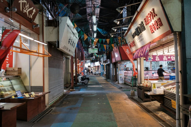 people are walking in the narrow street shopping area