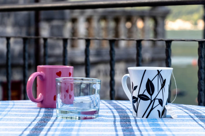 a table that has cups with vases on it