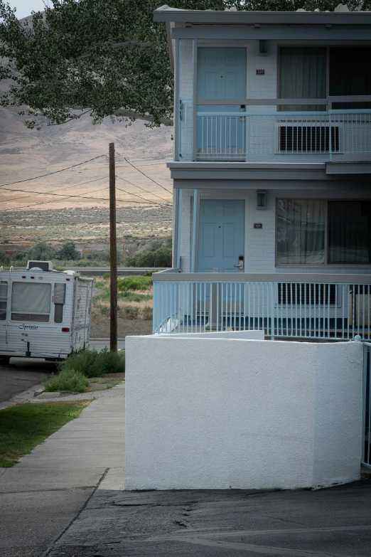 an older caravan parked near a building with balconies