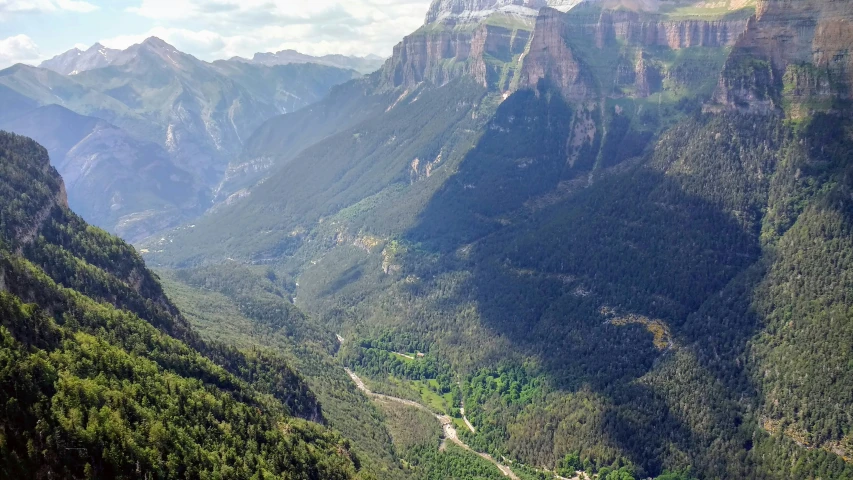 a scenic valley with lush green trees and cliffs