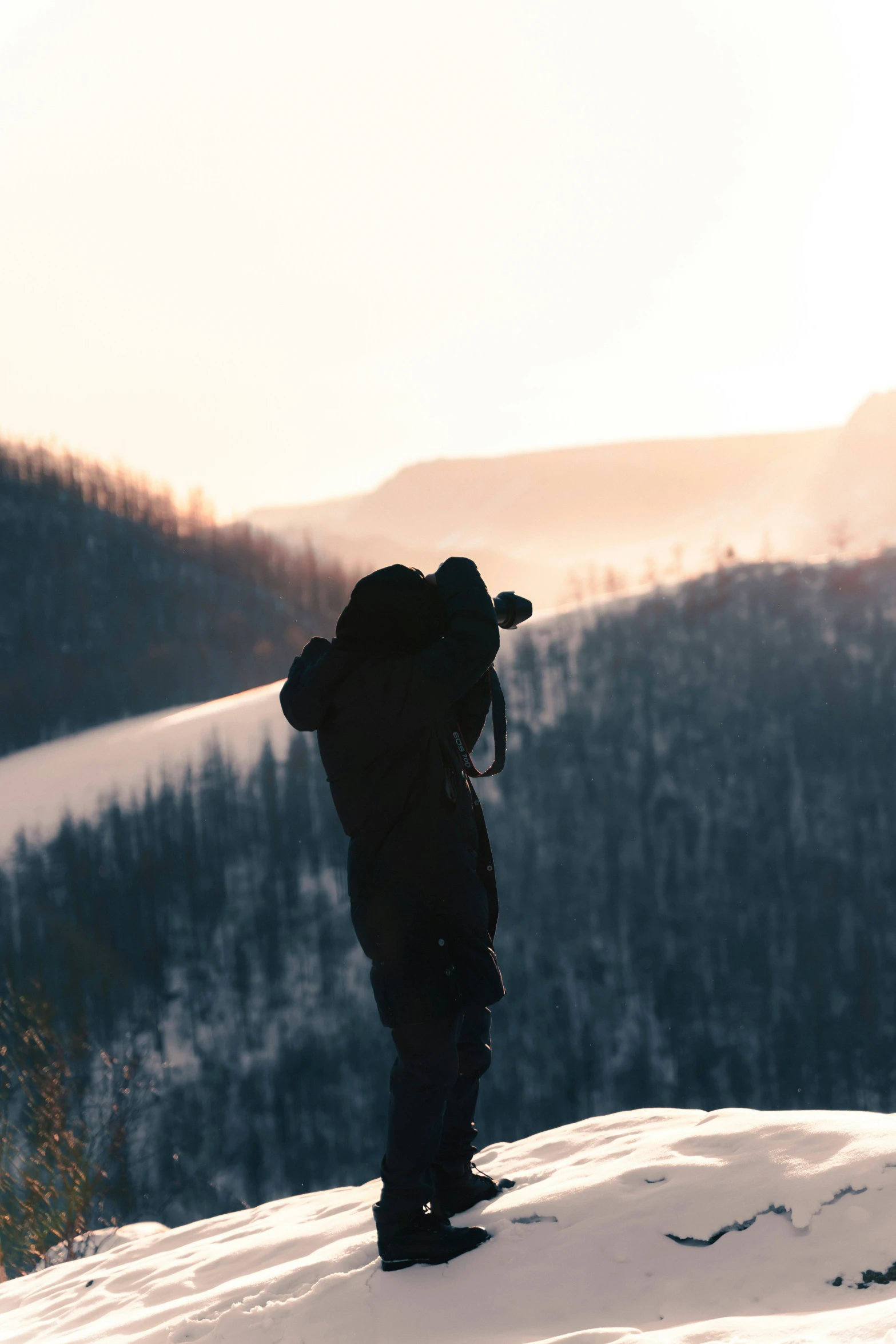 someone with a backpack standing on a snowy hill