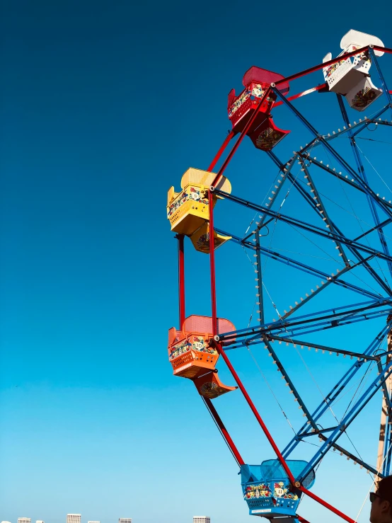 the ferris wheel is in color with a bright blue sky