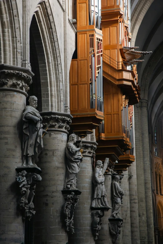 many sculptures sit on the outside wall of a cathedral