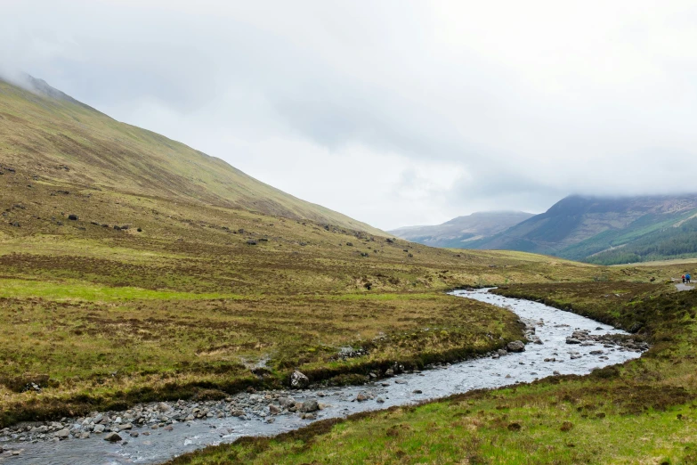 a small stream running through the middle of mountains