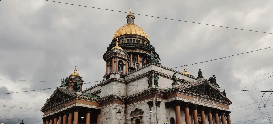 a white building with a gold dome and two towers