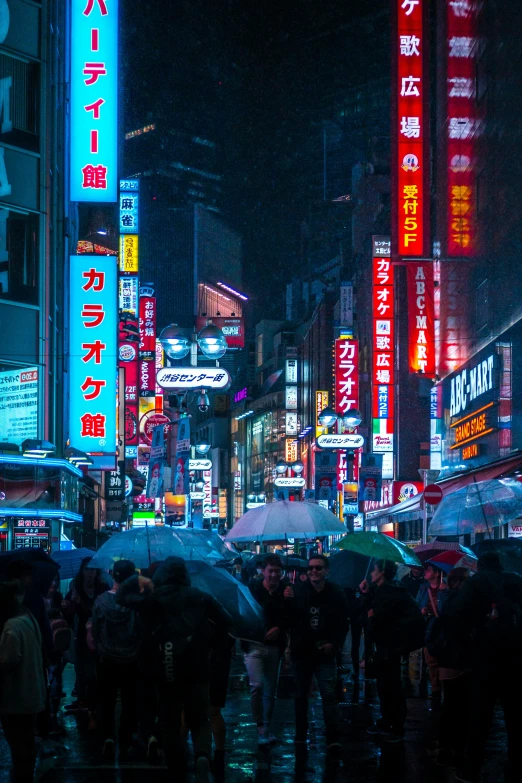 people with umbrellas standing outside in the rain