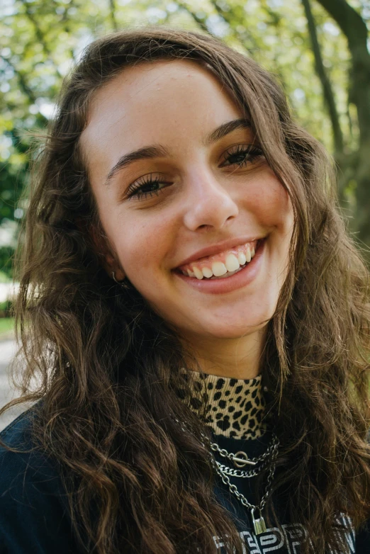 the young woman smiles while wearing an animal print shirt