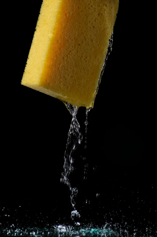 a cube of sponge under water as it is dropped