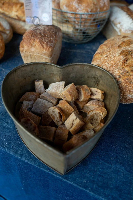 a heart shaped bowl filled with sliced up bread