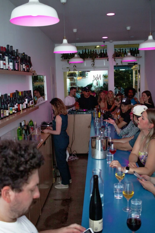 a large group of people at a long bar drinking and socializing