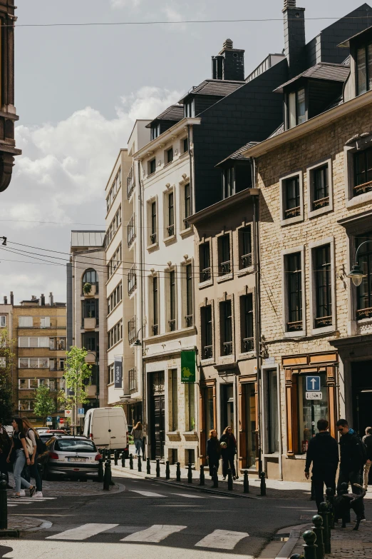 people are walking on the sidewalk in front of some buildings