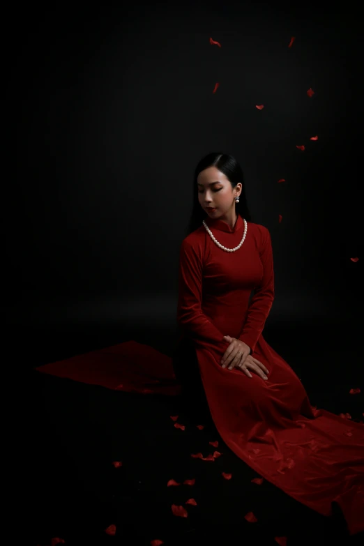 a woman in a red dress sitting down on the floor