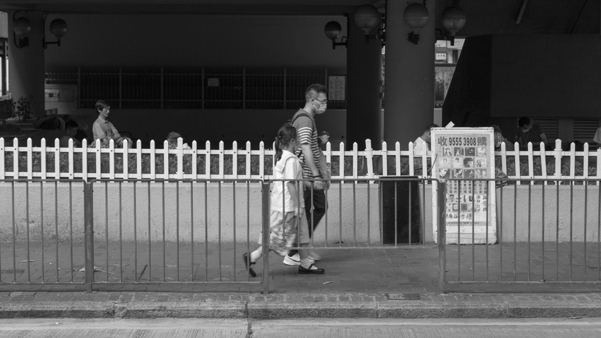 the woman is walking down the sidewalk carrying a bag