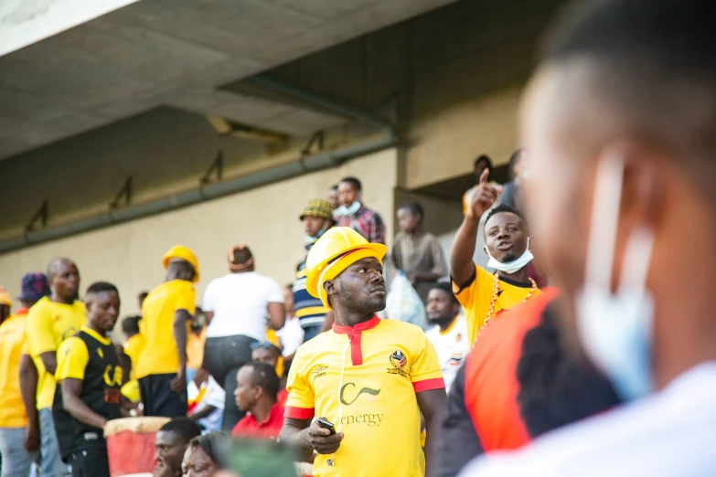 men in yellow and red uniform and hats singing on stage