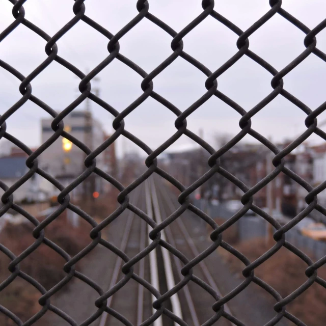 looking through a fence at a train coming around