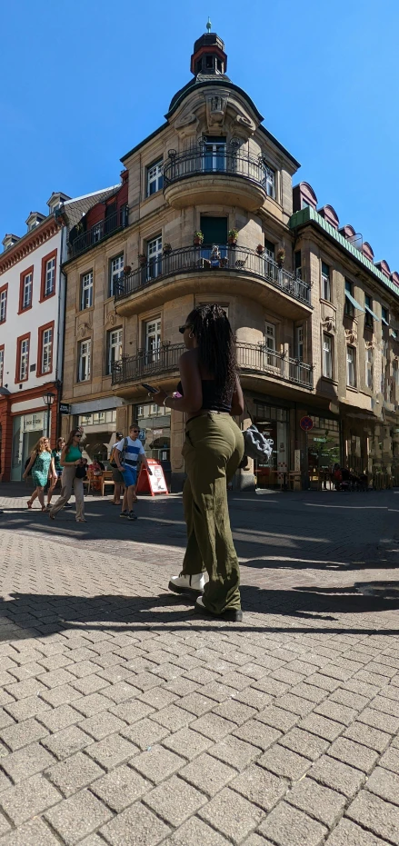 a woman taking a selfie in front of an apartment building