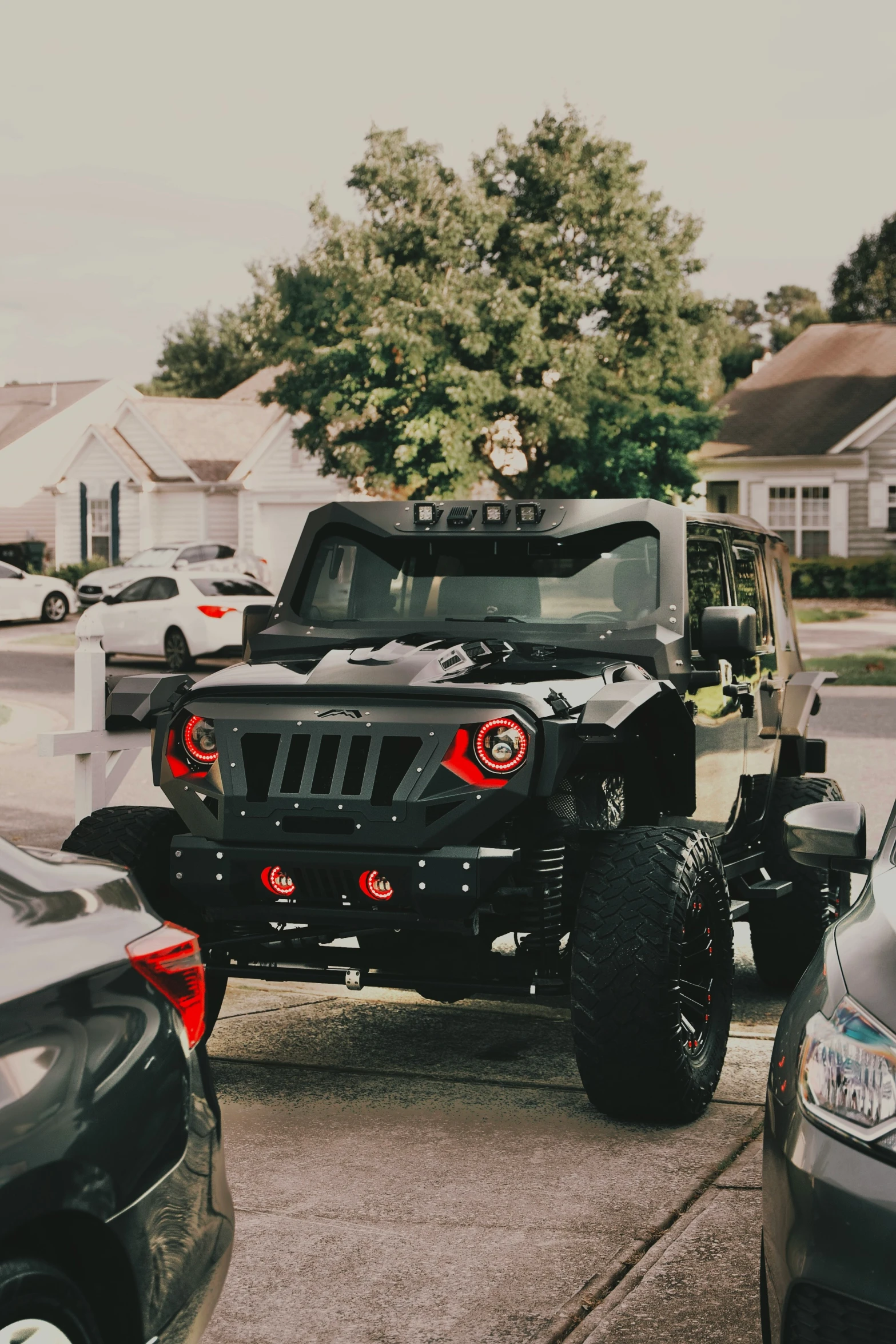 a jeep parked on a street with other vehicles