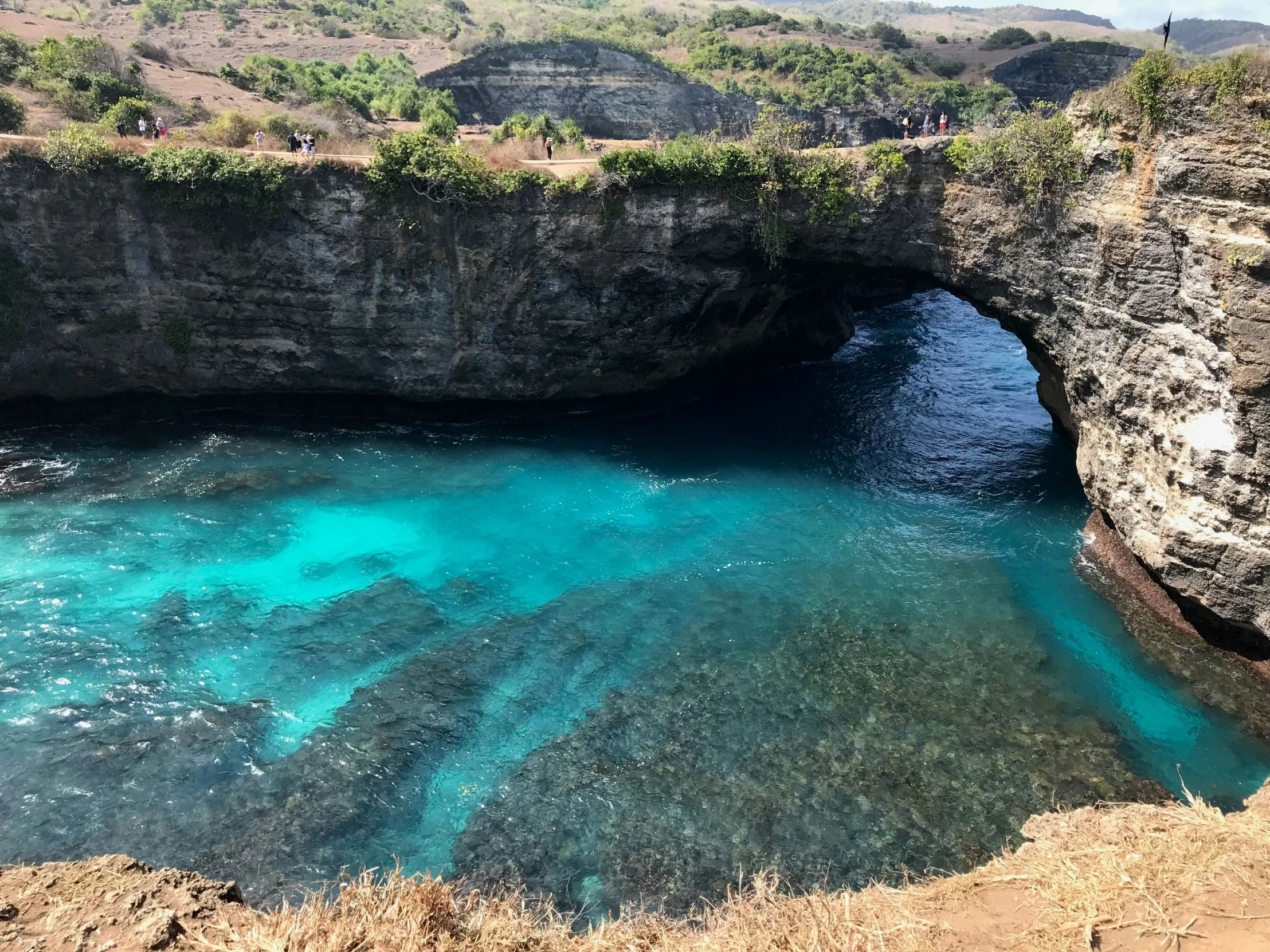 people sitting and standing around in front of blue water