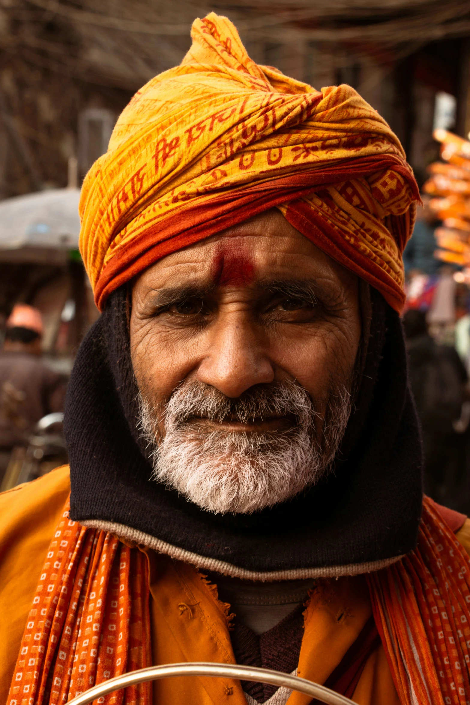 a man with a mustache and white beard wearing an orange turban