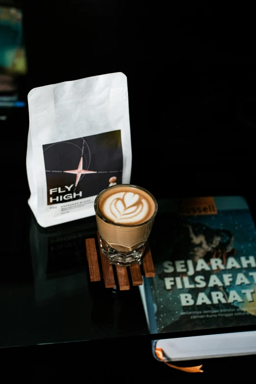 a cup of coffee and a stack of books on a table