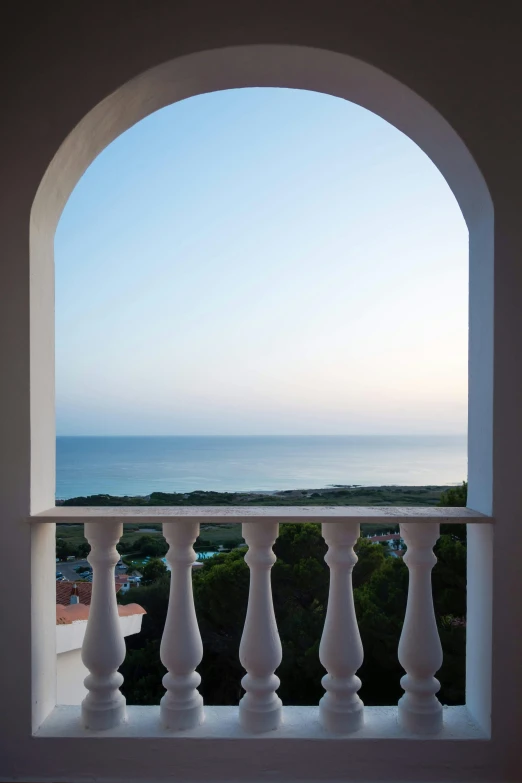 a white balcony that has a view of the ocean and the beach