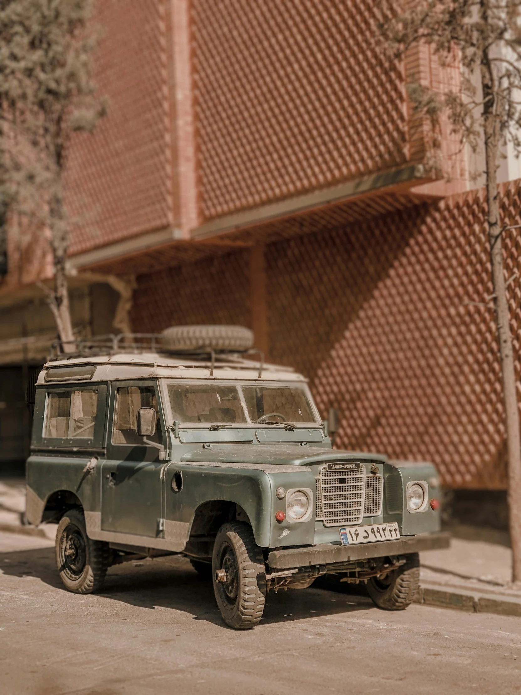 a green land rover parked next to a building