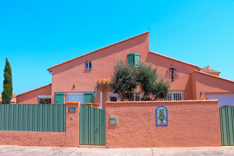 large pink house with orange stucco and brown roof