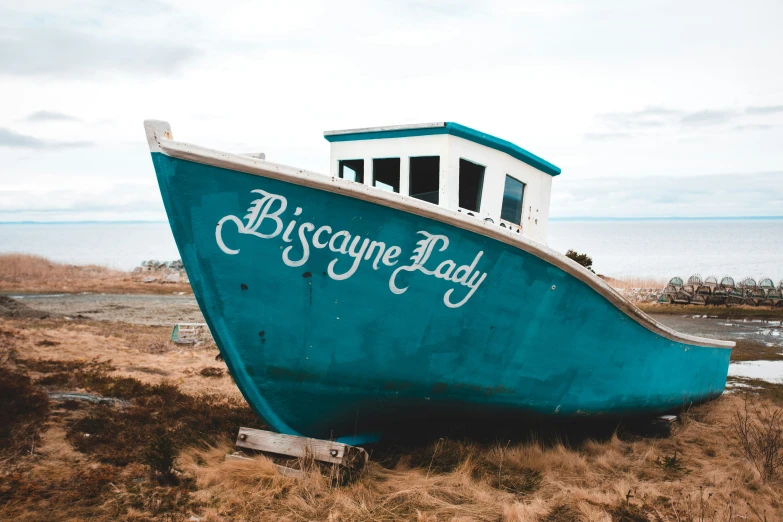 an old blue and white boat in the middle of nowhere