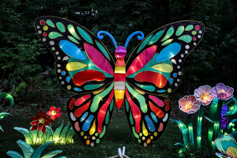 a erfly shaped garden sculpture with lights surrounding it