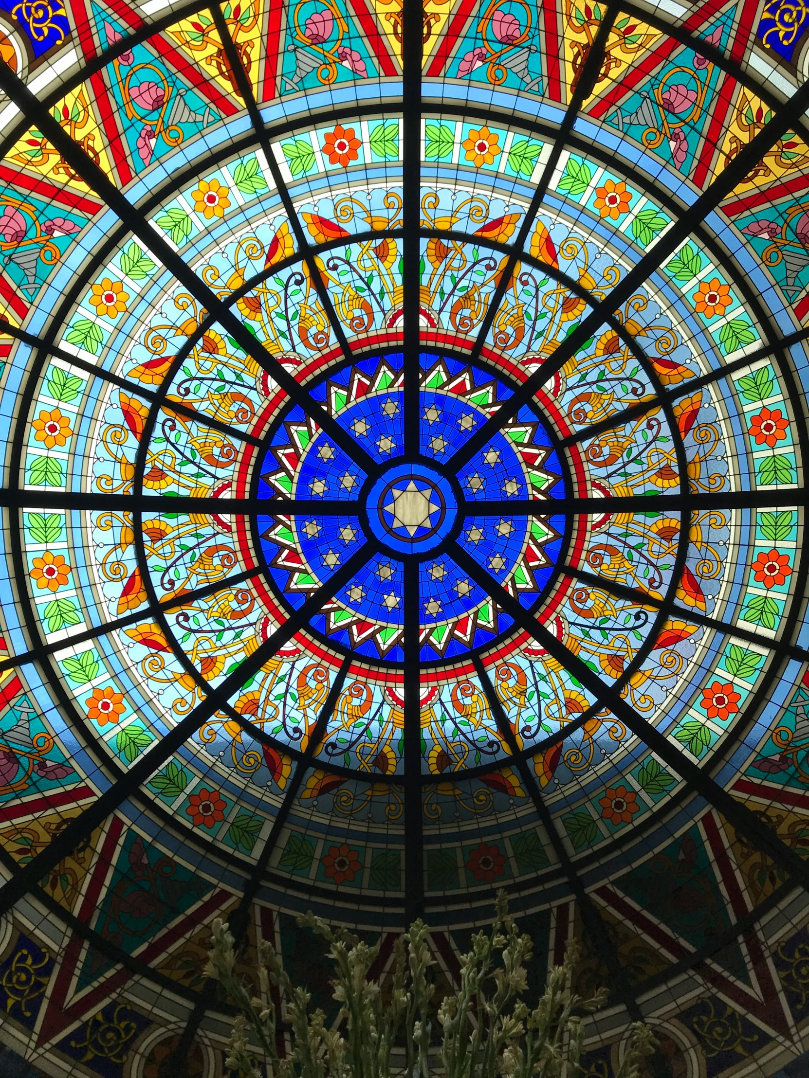 this is a round colorful glass window inside a church