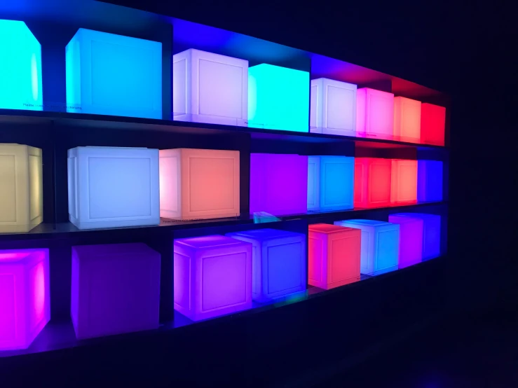 a wall of glowing shelves filled with a lot of different colors