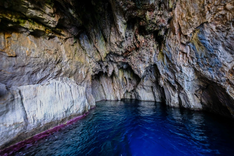 the pool has blue water beneath a large cliff