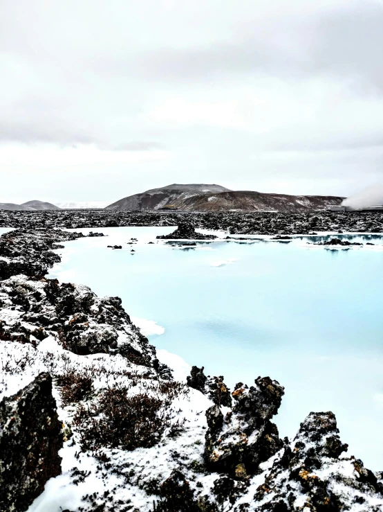 a landscape of rocky outcroppings with a pond at the end