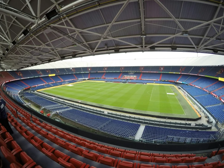 a soccer stadium with blue chairs and a big field