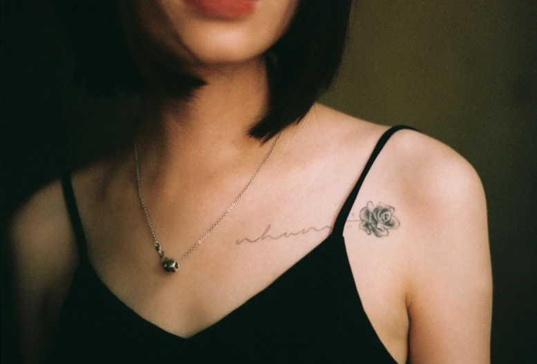 a girl's back with her arm tattoo on and the word love in the font