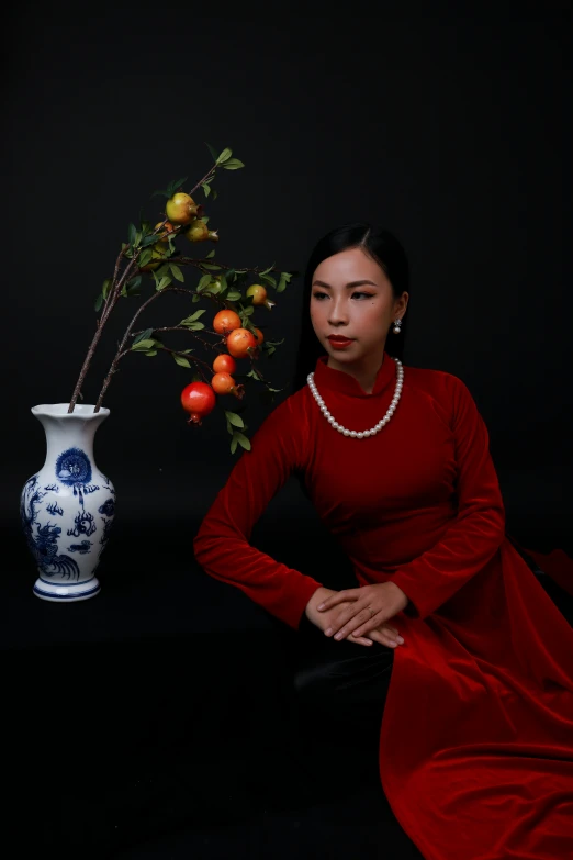 there is a woman in a red dress and a vase filled with flowers