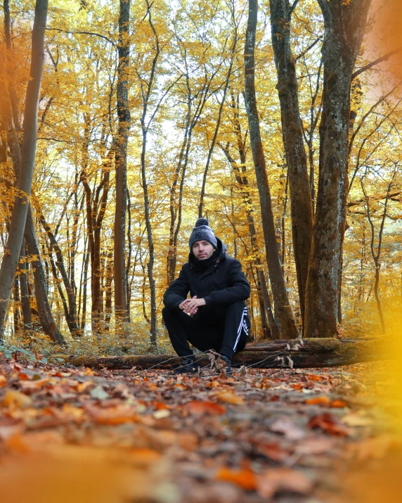 a woman squatting on a bench surrounded by leaves