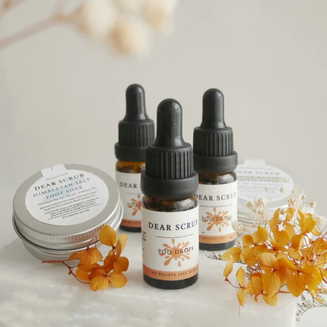 three bottle of essential oils and an orange flower