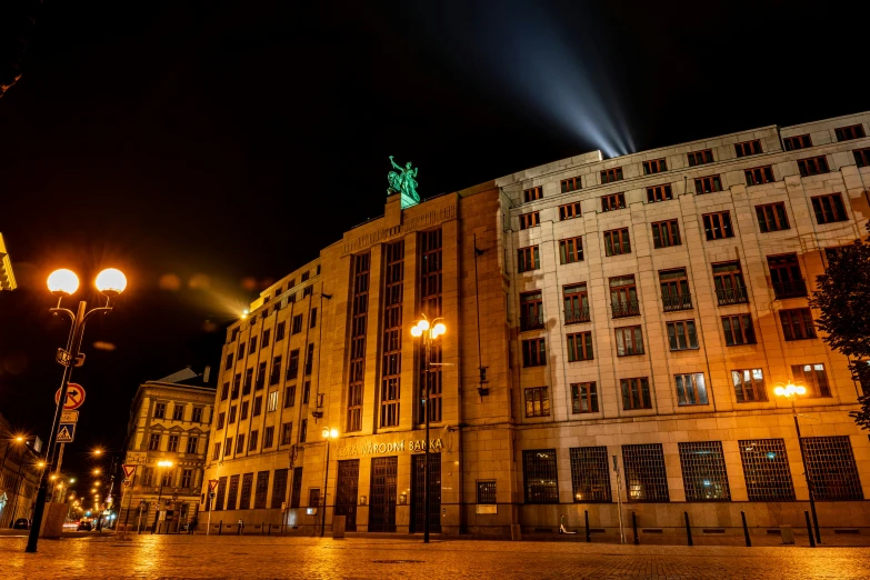 a tall building with two lights shine at night