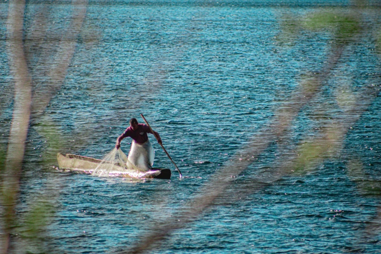 a man riding a paddle board on top of a lake