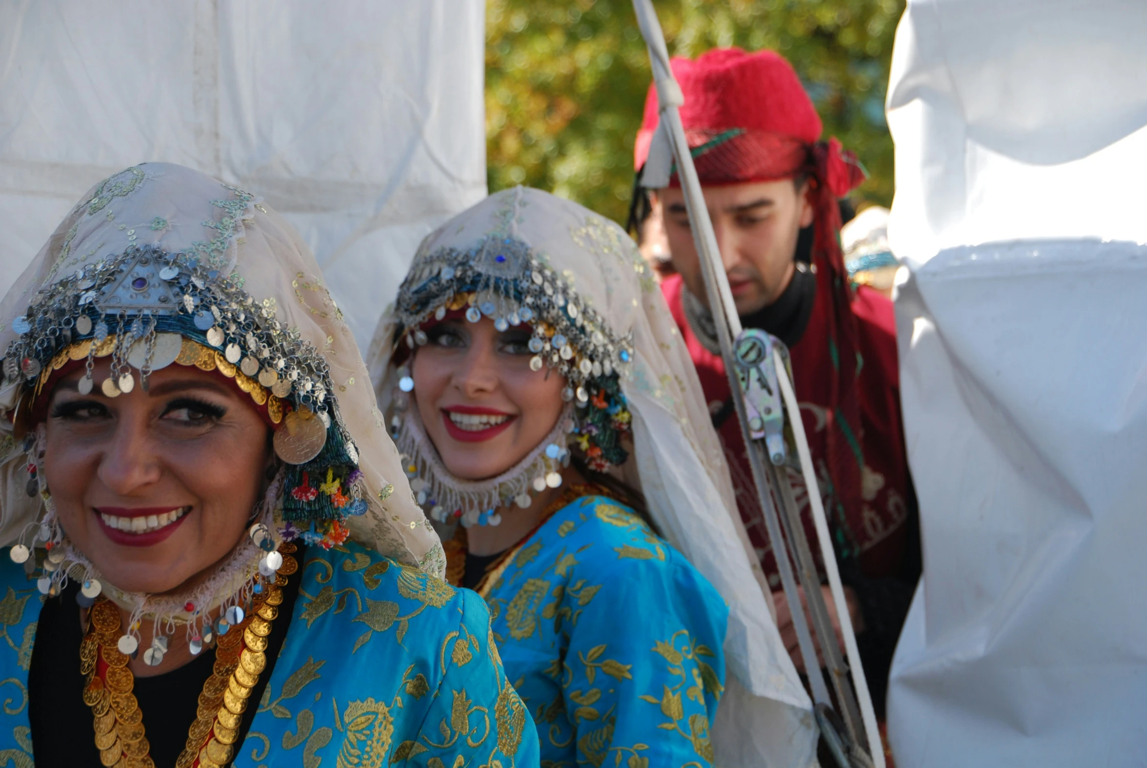 two women dressed in colorful costume with a flag