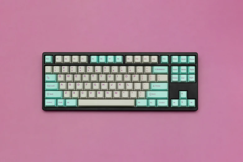 a pink background with a blue, green and black keyboard