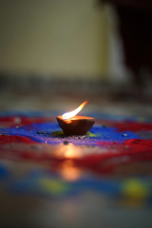 a candle floating on a plate sitting on the ground