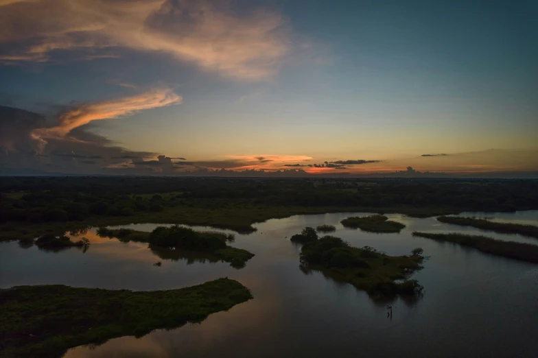 a river is sitting in front of a sunset with clouds in the background