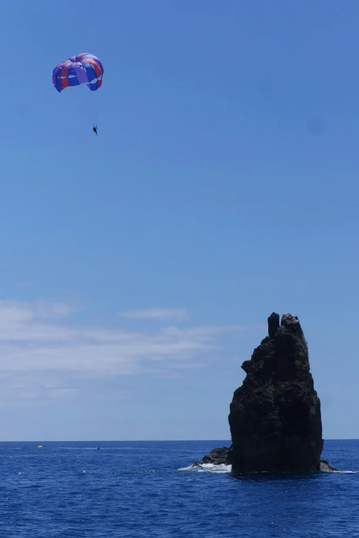 a large rock out in the middle of a body of water